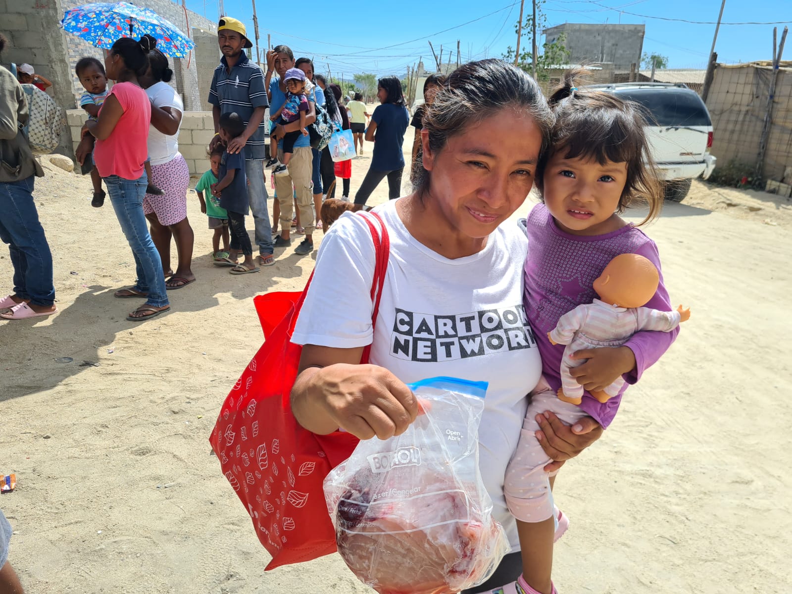 Children receiving fish from Black and BLue